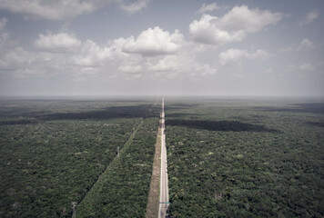 Aerial drone view of tropical jungle with jungle road and power lines in the Yucatan peninsula near Tulum on a cloudy day