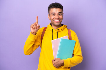 Young student Brazilian man isolated on purple background pointing up a great idea