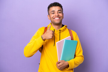 Fototapeta Young student Brazilian man isolated on purple background giving a thumbs up gesture obraz