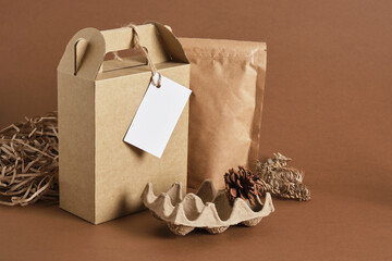 several different kraft packaging with a white empty mockup tag on a brown background,