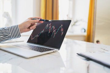 Trader trades stocks online stock exchange, statistics laptop screen workplace in the office