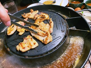 grill pork on hot pan plate. Japanese or Korean Cuisine Jingisukan or Yakiniku barbecue. Thai traditional barbecue roasted buffet. Enjoy eating lifestyle concept.