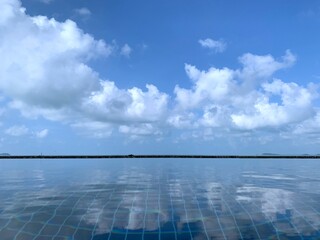 infinity pool at luxury hotel against blue sky cloudy background , tropical resort. Relaxing, summer, travel, holiday, vacation and weekend concept