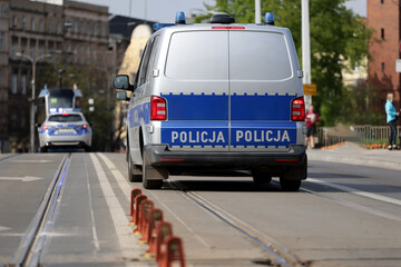 Radiowóz polskiej policji w mieście podczas patrolu na sygnale alarmowym. 