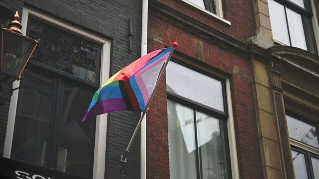 Modern, progress LGBTQ pride flag during pride month, including black stripe for people of color. Rainbow gay, transgender, queer symbol of equality. Celebration of pride month.