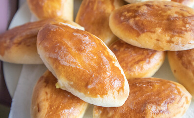 Lots of delicious freshly baked hot pies with stuffing, food background, close-up, Russian cuisine