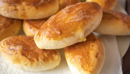 Lots of delicious freshly baked hot pies with stuffing, food background, close-up, Russian cuisine