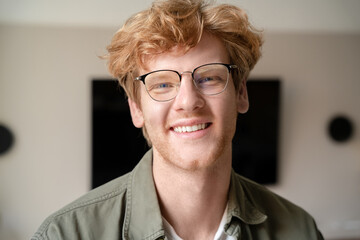 Headshot portrait of positive smiling young ginger british man