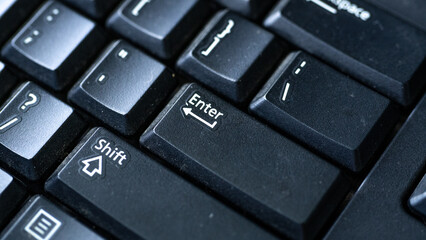 Selective focus on enter key in solid black color keyboard. - obrazy, fototapety, plakaty