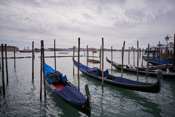 Fototapeta premium View from Piazza San Marco to Lagoon in Venice. Gondola tied on wooden pole Clouds over Venice