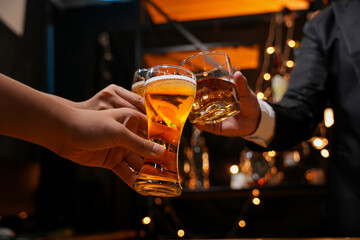 food and drink male friends are happy drinking beer and clinking glasses at a bar or pub.