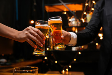 food and drink male friends are happy drinking beer and clinking glasses at a bar or pub.