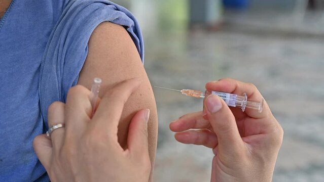 Healthcare worker giving a shot of Influenza vaccine to patient. Influenza vaccines are vaccines that protect against flu.
