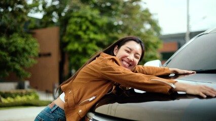 Surprised young asian woman getting the new car. She hugged his car and was very happy. Buy or rent car concept. - Powered by Adobe