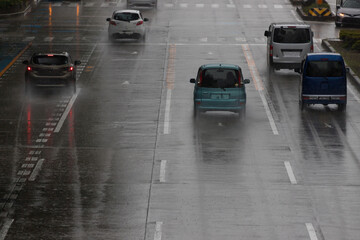 夏の雨の日に道路で走っている車の姿