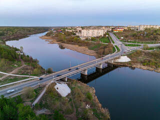Obraz premium Beautiful view of the bridge across the Iset river in the city of Kamensk-Uralsky at sunset in spring. Kamensk-Uralskiy, Sverdlovsk region, Ural mountains, Russia.