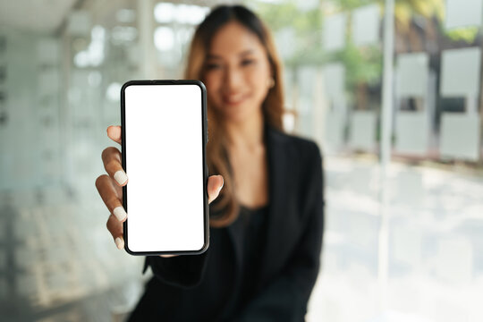 Mockup image of a beautiful woman holding mobile phone with blank white screen.