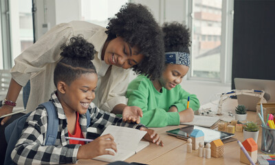 Classroom with diverse learners of happily African American students and teacher doing activities together. The teacher is teaching, guiding and talking to the children in diverse.