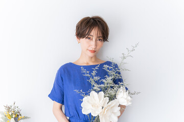 お花を持ったきれいなショートヘアーの美しい日本人女性
