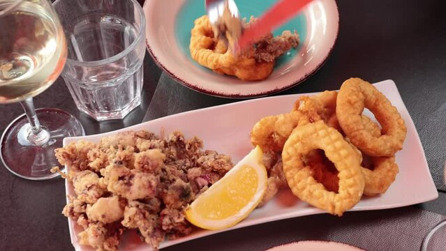 Popular appetizer of Spanish cuisine is squid a la romana and baby andalusian squids served with a slice of lemon. High quality 4k footage