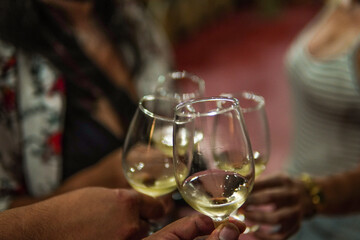 four glasses toasting with white wine