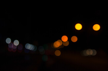 bokeh background with the light of street lamps and car lights at night out of focus