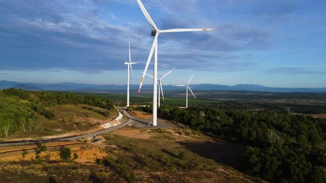 Four Giant Wind Turbines With Propellers Slowly Spinning In The Wind Background With Blue Sky In South Vietnam. - Drone Panning Shot