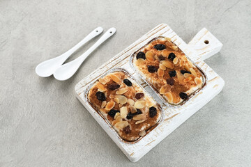 Klappertaart, Indonesian traditional dessert, from Manado. Coconut custard cake with raisin and almond topping, dusted with cinnamon powder, Dutch influenced dessert. 
