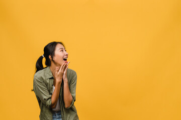Young Asia lady feel happiness with positive expression, joyful surprise funky, dressed in casual cloth isolated on yellow background. Happy adorable glad woman rejoices success. Facial expression.