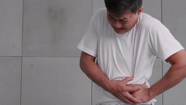 Asian man has severe stomach pains caused by appendicitis.