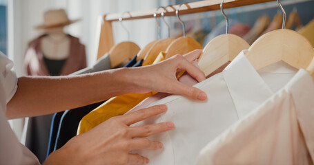 Close-up hand Cheerful young Asia lady shopping new outfit for gift  choose cloth and dress in mall...