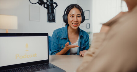 Asia girl radio host record podcast use microphone wear headphone interview celebrity guest content conversation talk and listen in her room. Audio podcast from home, Sound equipment concept.