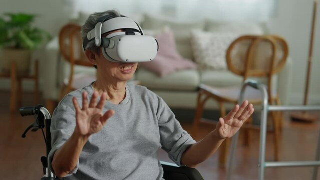 lonely ole male Disabled Senior Man in a Wheelchair Gesturing and concentrate While Wearing the Virtual Reality Goggles at Home in the Livingroom,Shot of a senior man in a wheelchair wear vr headset