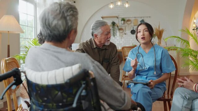 happiness Cheerful elderly woman and men talking with female caregiver nurse doctor having health checking consult at living area,Caretakers with senior couple sitting in living room at nursing home 