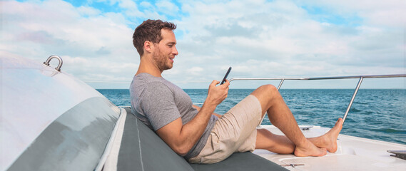 Phone using on cruise ship. Man luxury travel texting with data on yacht boat relaxing on deck...