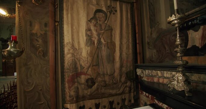 Slow motion and wide shot of an ancient and beautiful tapestry in a small chapel of a big church in Italy. The church is called Basilica di Desio