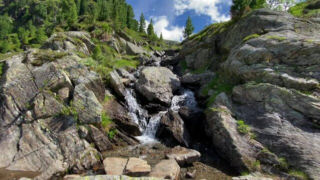 Small river in the alps between rocks and with bubbling water, flowing down from a mountain in Austria