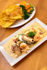 Sea food with white sauce and patacones tostones