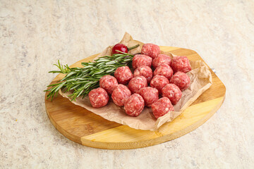 Raw uncooked beef meatballs served rosemary