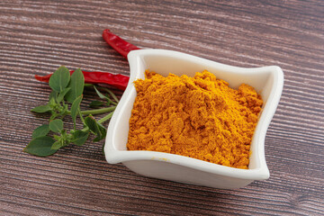 Yellow vibrant curcuma powder in the bowl