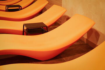 Empty orange sunbeds in hotel spa center