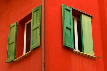 Fototapeta na wymiar Colourful faceade and wooden window shutters, Bologna, Italy