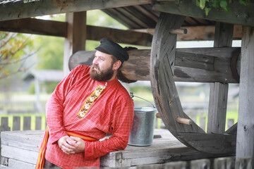Traditional Slavic rituals in the rustic style. Outdoor in summer. Slavic village farm. Peasants in elegant robes.
