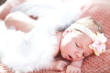 A newborn baby lies in her mother's arms. A beautiful baby of European appearance is sleeping.