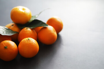 Citrus fruits on a gray background. Tangerines with leaves. Christmas fruit.