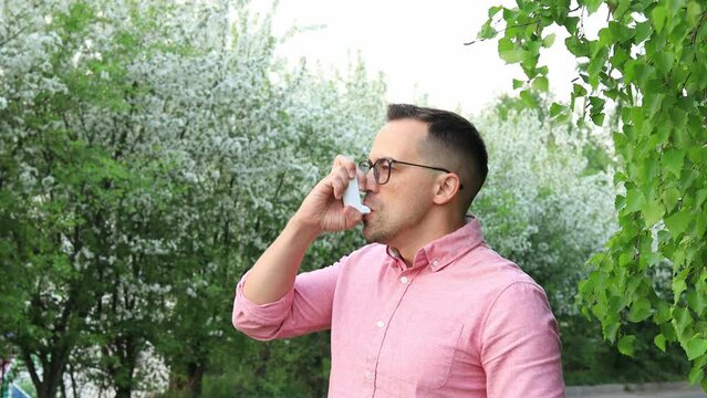 Man using an inhaler during an asthma attack in the park
