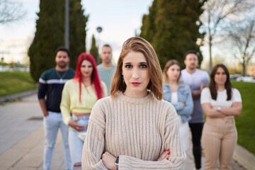 Confident woman looking at camera and smiling while standing with crossed arms in front of group of people. Friendship, union and team concept.