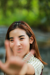 Naklejka premium portrait of lady doing highfive,focus on girl's face,nature as background