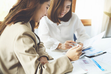 Negotiation, Analysis, Discussion, Asian woman economist and marketer pointing to a financial data sheet to plan investments to prevent risks and losses for the company