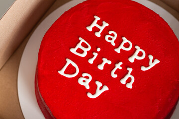 Birthday cake with lettering on top isolated on red. Red round birthday cake with an inscription...